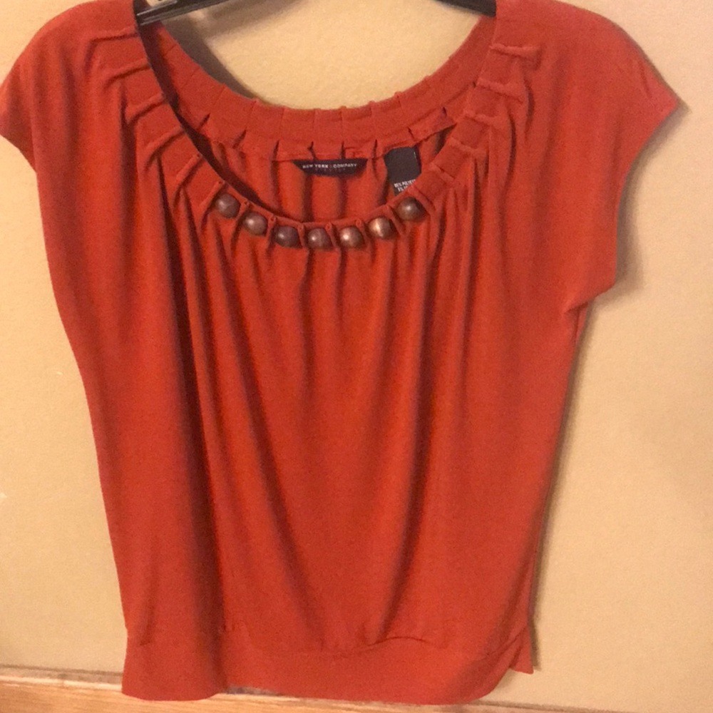 Rust colored top with wooden bead collar.